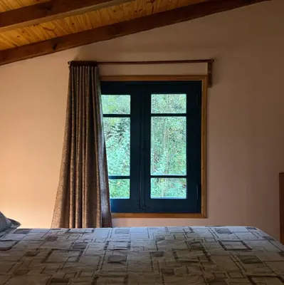 a bedroom with a bed and a window at Lila Casas de Montaña in La Cumbrecita