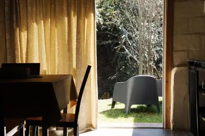 a dining room with a table and a large window at Lila Casas de Montaña in La Cumbrecita