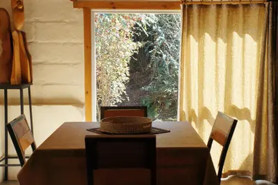 a table with a basket on it in front of a window at Lila Casas de Montaña in La Cumbrecita