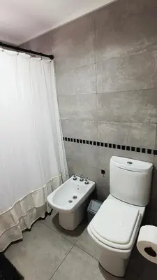 a bathroom with a white toilet and a sink at Departamento en Carlos Paz con vistas y céntrico in Villa Carlos Paz