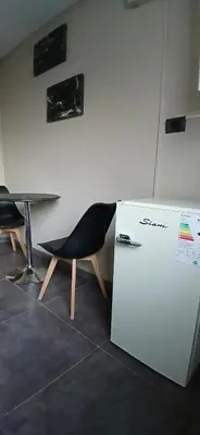 a chair sitting next to a table and a refrigerator at aleyluna in Berrotarán