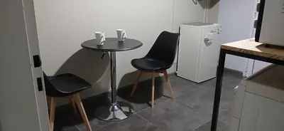 a small table with two chairs and a small refrigerator at aleyluna in Berrotarán