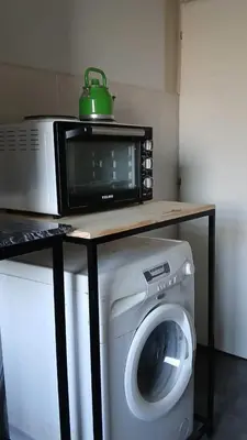 a microwave sitting on top of a washing machine at aleyluna in Berrotarán