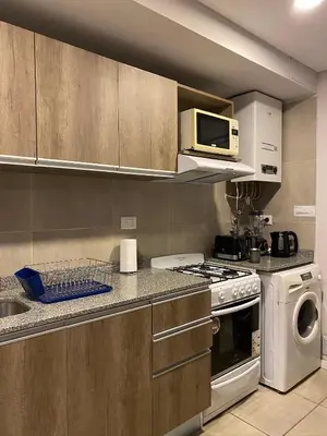a kitchen with a stove and a microwave at Dpto Premium en Torre Cofico con cochera incluida - Pileta en Terraza in Cordoba