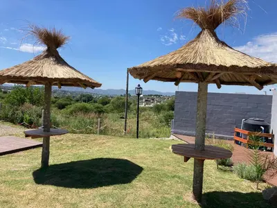 two large straw umbrellas sitting in a yard at Soligna-alquiler in Villa Santa Cruz del Lago