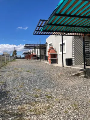a gravel road next to a building with a green canopy at Soligna-alquiler in Villa Santa Cruz del Lago