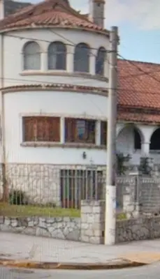 a white house with a pole in front of it at Balcón al Tajamar in Alta Gracia