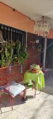 a patio with a table and chairs and bananas at Antu Kuyen Hostel in Villa Carlos Paz