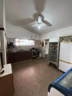 a large kitchen with a refrigerator and a stove at Antu Kuyen Hostel in Villa Carlos Paz