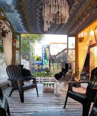 a porch with two chairs and a swing at Antu Kuyen Hostel in Villa Carlos Paz