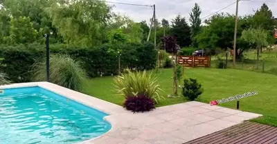 a swimming pool in a yard next to a lawn at Casa en las sierras de córdoba in Tanti