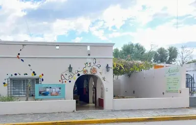 a white building with an archway in a street at APART HOTEl ACUARELA in Mina Clavero