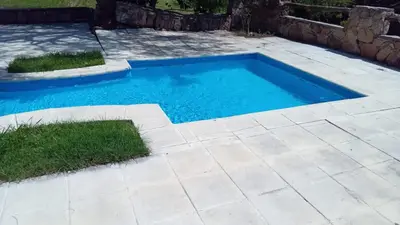 a swimming pool in a yard with a patio at APART HOTEl ACUARELA in Mina Clavero