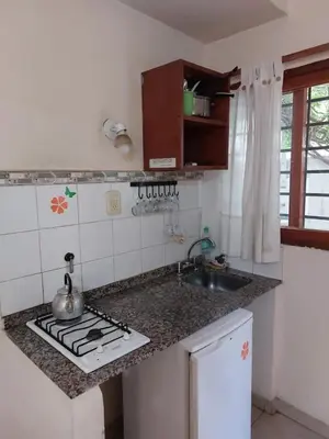 a kitchen with a sink and a stove top oven at APART HOTEl ACUARELA in Mina Clavero