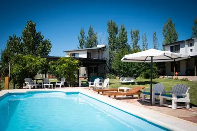 a swimming pool with chairs and an umbrella next to a house at Colores de Panaholma in Panaholma