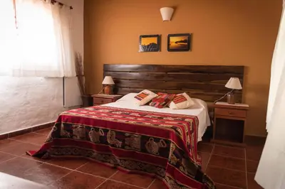 a bedroom with a bed and two tables with lamps at Colores de Panaholma in Panaholma
