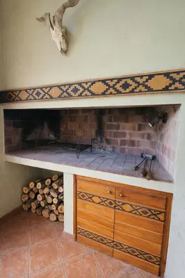 a fireplace with a shelf and a brick wall at Chalet Alpino en las Sierras in Villa del Dique