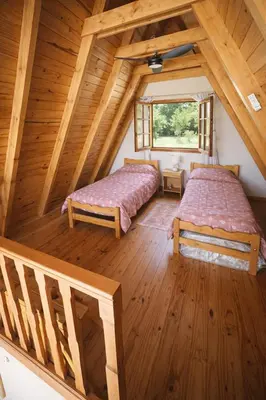 two beds in a room in a log cabin at Chalet Alpino en las Sierras in Villa del Dique