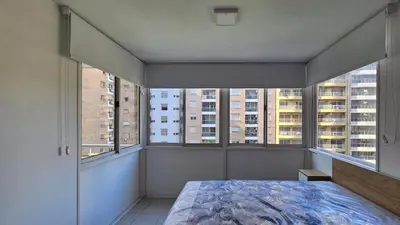 a bedroom with a bed and two large windows at Paraná 640 in Cordoba