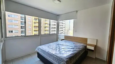 a bedroom with a bed in a room with windows at Paraná 640 in Cordoba