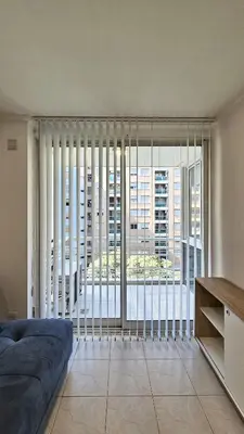 a living room with a large window with blinds at Paraná 640 in Cordoba