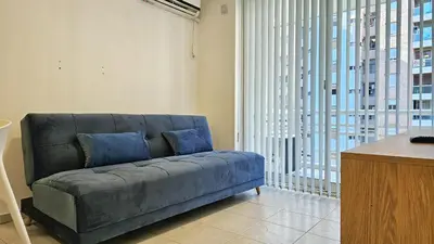 a blue couch in a room with a large window at Paraná 640 in Cordoba