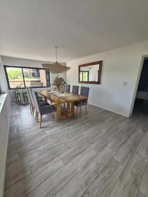 a dining room with a wooden table and chairs at Casa con hermosa vista al lago in Villa Carlos Paz