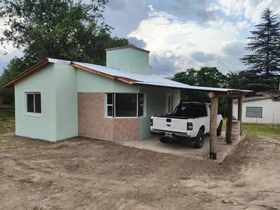 a white truck parked in front of a small house at Cabana Cecilia in Villa Icho Cruz
