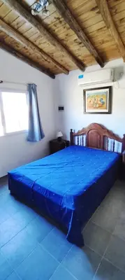 a bedroom with a large blue bed in a room at Cabana Cecilia in Villa Icho Cruz