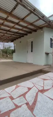 a large white building with awning and a patio at Cabana Cecilia in Villa Icho Cruz