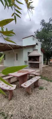 a picnic table in front of a building with a grill at Cabana Cecilia in Villa Icho Cruz