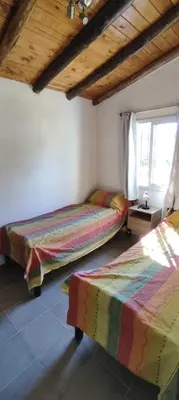 a bedroom with two beds and a window at Cabana Cecilia in Villa Icho Cruz