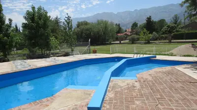 a swimming pool in a backyard with mountains in the background at Ayres del Bosque in Merlo