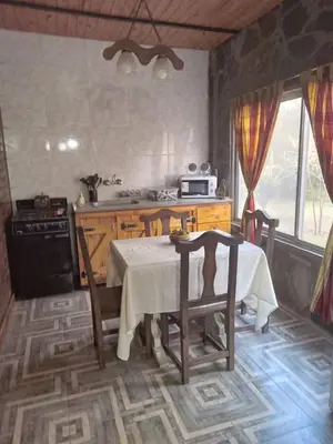a kitchen with a table and a stove and a table and chairs at Lo de iaia in Carpintería
