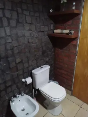 a bathroom with a white toilet and a sink at Lo de iaia in Carpintería