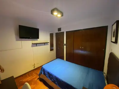 a bedroom with a bed and a flat screen tv at Departamento Amoblado in Cordoba