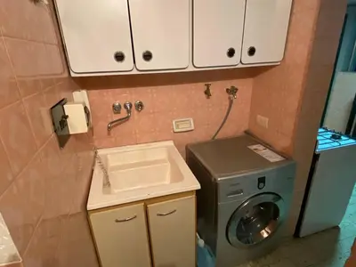 a small bathroom with a washing machine and a sink at Departamento Amoblado in Cordoba
