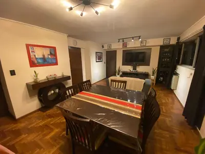 a living room with a table and chairs and a television at Departamento Amoblado in Cordoba