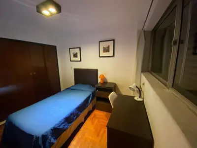 a bedroom with a blue bed and a desk at Departamento Amoblado in Cordoba