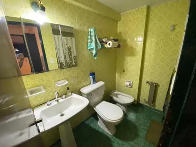 a bathroom with a white toilet and a sink at Departamento Amoblado in Cordoba