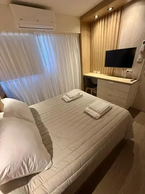 a bedroom with a bed and a desk with a television at Departamento Elegante y Funcional SS10 in Cordoba