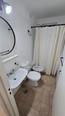 a white bathroom with a toilet and a sink at Dpto zona NUEVO CENTRO shopping y PATIO OLMOS in Cordoba