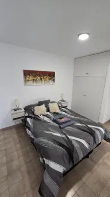 a bed in a room with a painting on the wall at Dpto zona NUEVO CENTRO shopping y PATIO OLMOS in Cordoba