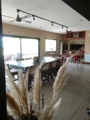 a large dining room with a table and chairs at Sobre lago Los Molinos in Villa Anizacate