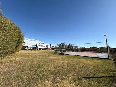 a tennis court with a fence in a field at Sobre lago Los Molinos in Villa Anizacate