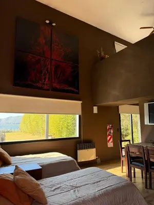 a bedroom with two beds and a large window at Sobre lago Los Molinos in Villa Anizacate