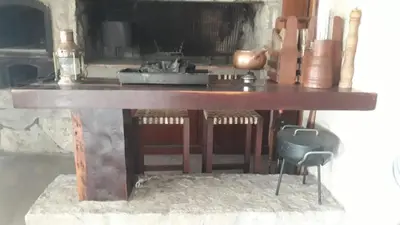 a wooden table in a room with a stove at Sobre lago Los Molinos in Villa Anizacate