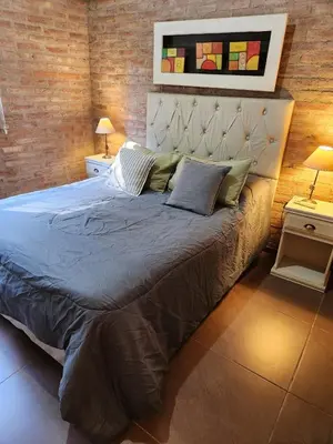 a bedroom with a large bed with blue sheets and pillows at Rio Sereno in Santa Rosa de Calamuchita