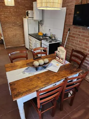 a kitchen with a wooden table with chairs at Rio Sereno in Santa Rosa de Calamuchita