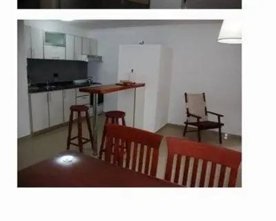 a kitchen with a table and chairs in a room at Dulces Sueños in Villa Carlos Paz